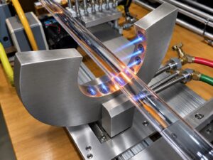 Automatic quartz bake-out machine at TCS Technologies superheating quartz tubing under flowing argon gas to manufacture premium UV curing lamps.